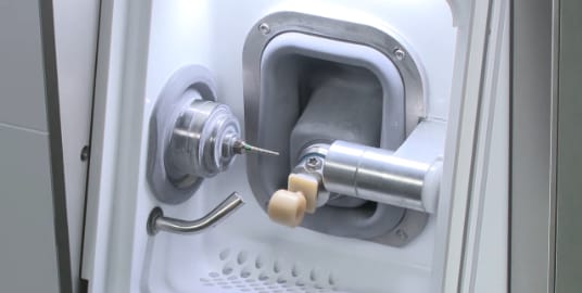 Shot of the same-day crown milling machine haven milled a perfect fitting crown to be used as a final restoration.